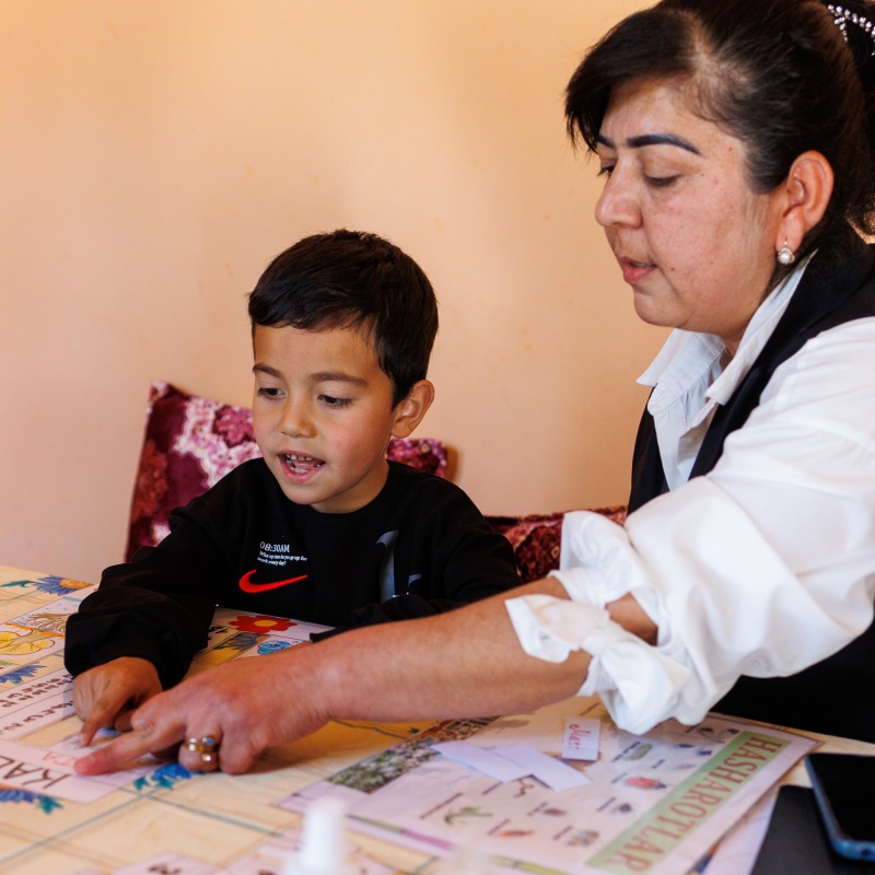 Hondamir learning through play-based activities with his teacher, Aziza. Credit: GPE/Federico Scoppa
