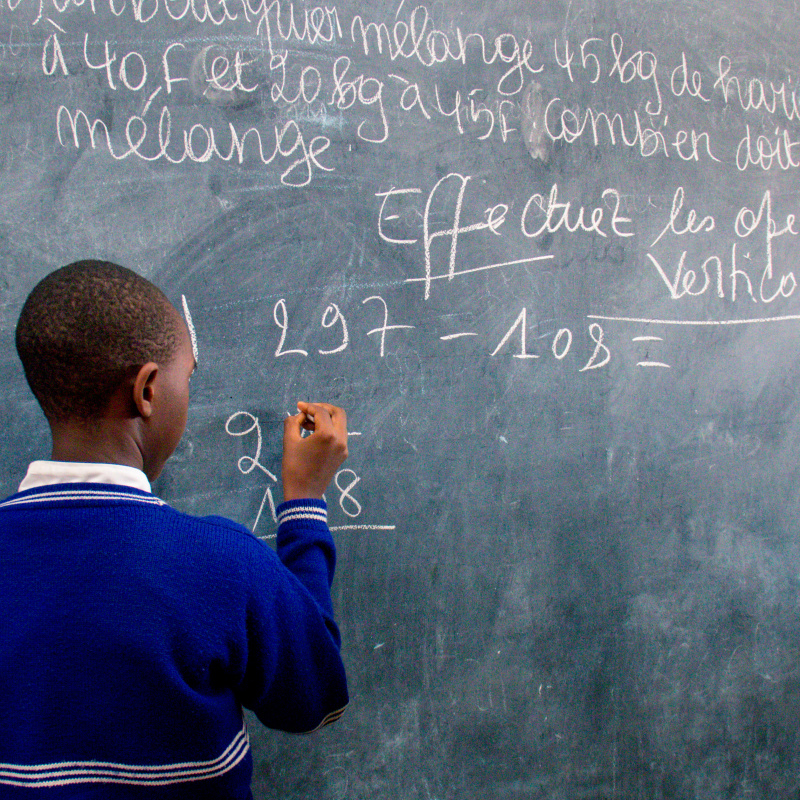 Student writing on the black board. Burundi.