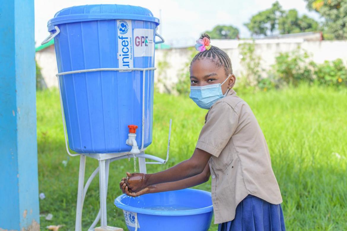 Angela, 10, washes her hands before entering class at Sebastien Mafouta Primary School. Credit: UNICEF/2021/MARANATHA