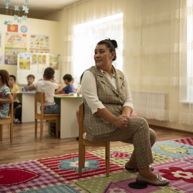 Aidana Azatovna, teacher at Ak-Bulak Kindergarten, looks towards her class on Monday, June 20, 2022, in Grozd, Kyrgyz Republic. Credit: GPE/Maxime Fossat
